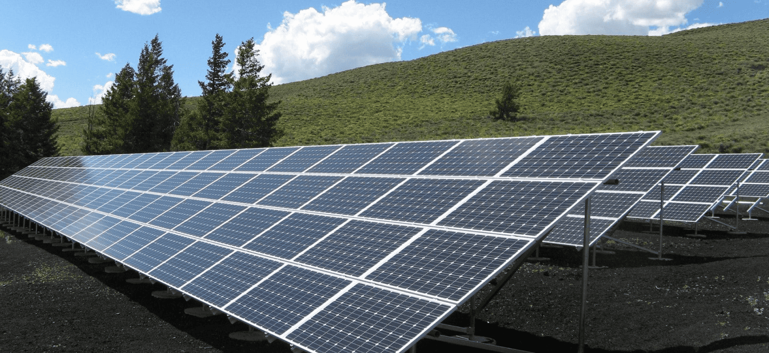 Aerial view of a large solar farm with thousands of photovoltaic panels installed under clear skies for high energy production.