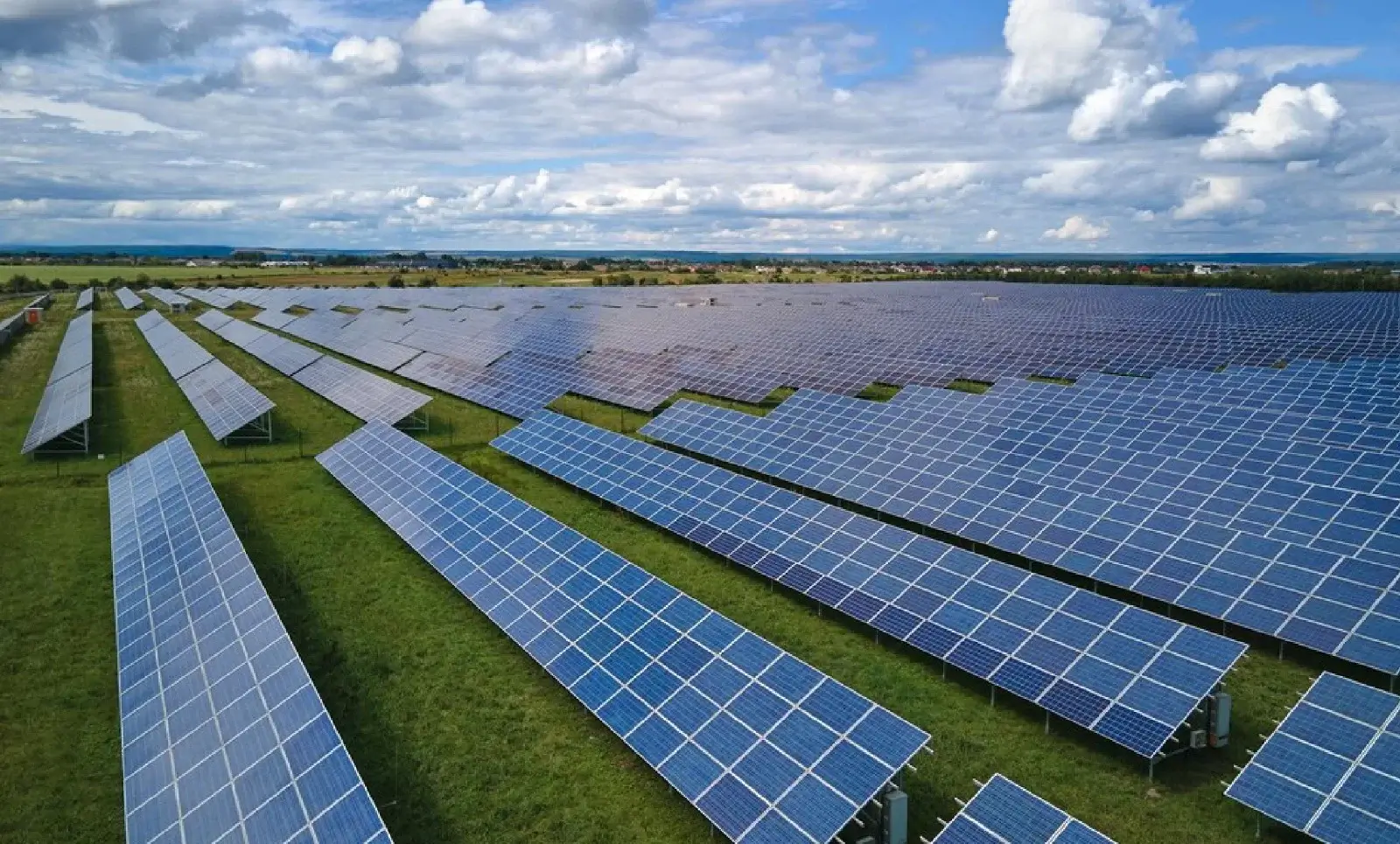 Ground mounted solar power plant with rows of solar panels in an open field
