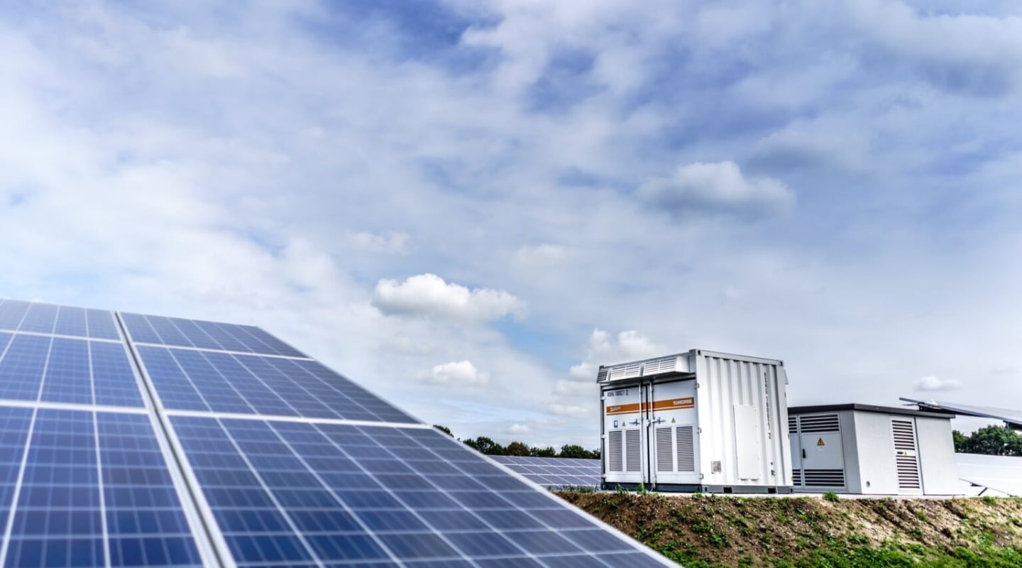 Battery storage units connected to solar panels at a power generation site