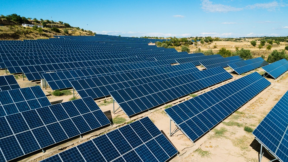 Commercial solar power system with rows of ground mounted solar panels on open land
