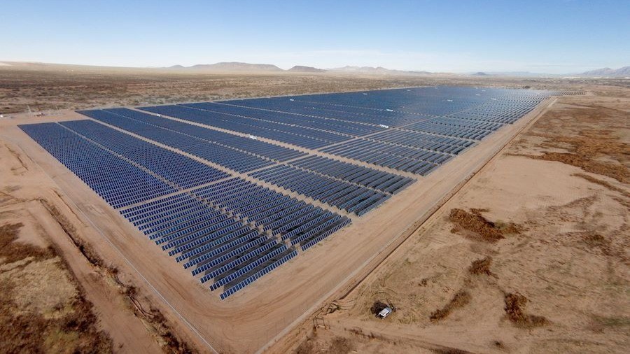 Aerial view of a large solar power plant installed across open land 