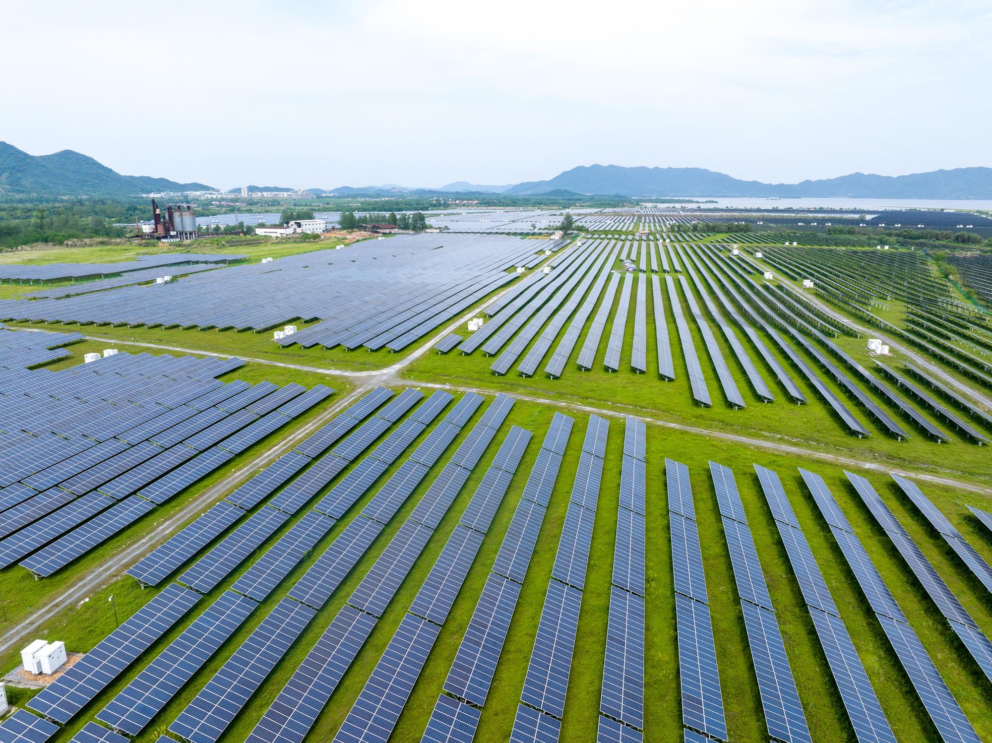 Large-scale solar power plant with ground-mounted photovoltaic panels providing reliable renewable energy for industrial and commercial business operations